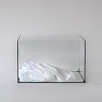 Ein Tuch liegt in einem Glaskasten.